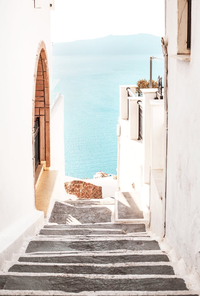 Beautiful whitewashed steps descending to the azure sea, creating a serene Mediterranean ambiance.